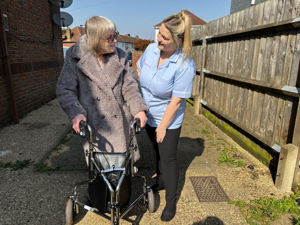 Comfort Care at Home nurse helping lady walk with walking aid